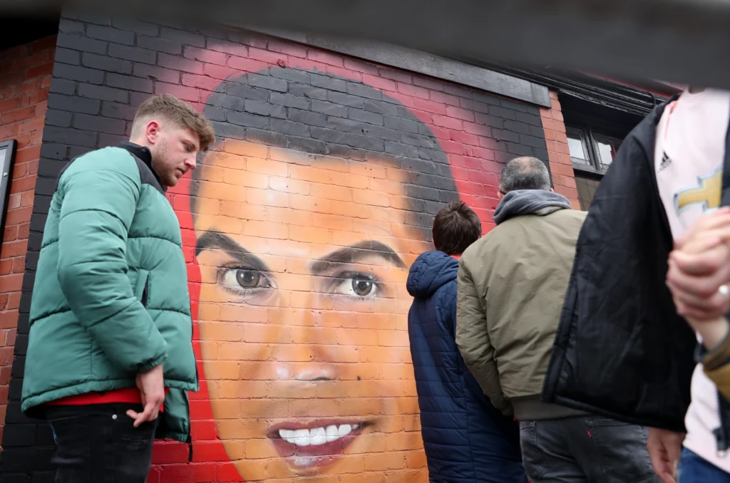 Photo of fans walking past a mural of Cristiano Ronaldo prior to kick off between Manchester United and Brentford at Old Trafford on May 2, 2022.